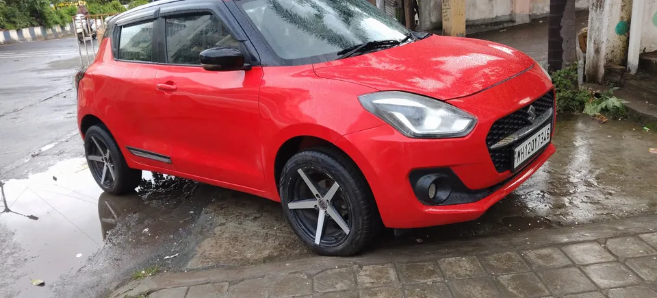 Red hatchback photographed from the side and front